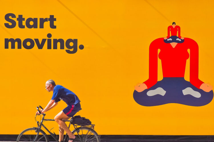Canva - Cyclist in Front of Yellow Billboard (1)